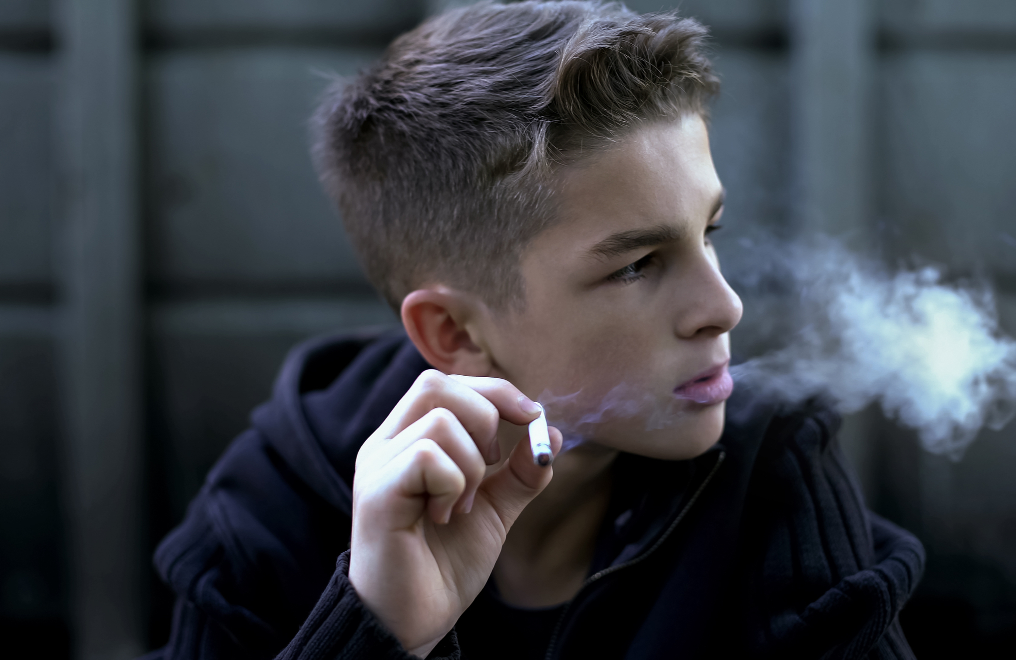 Teen smokes cigarette then sticks